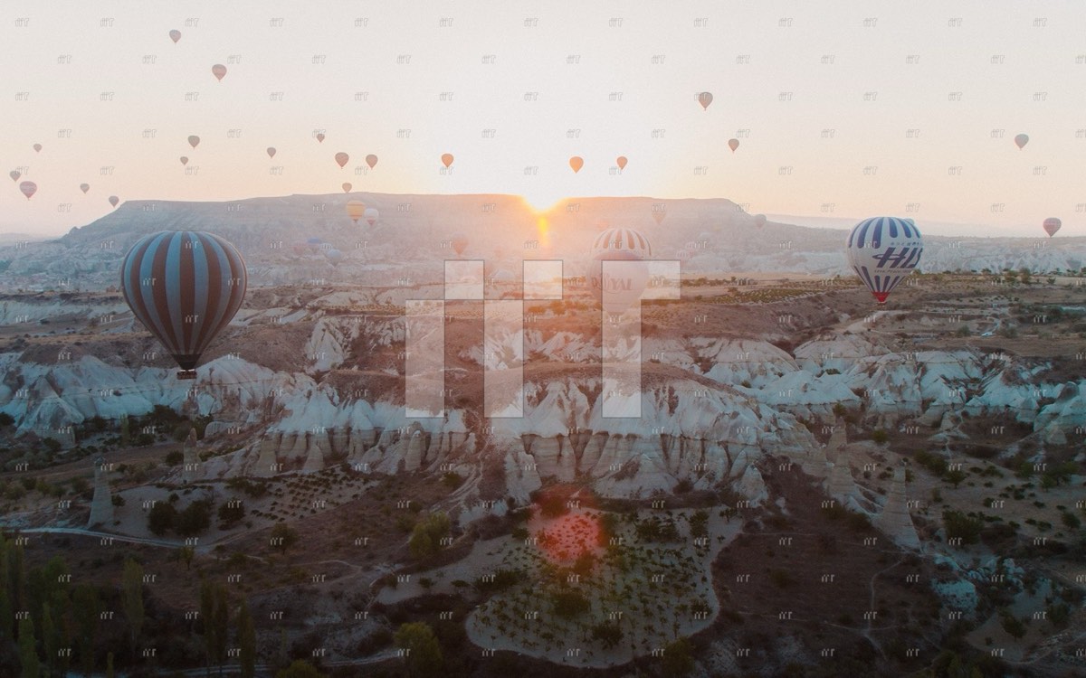 Hot-air balloons rising over the rocky valleys of Cappadocia at sunrise