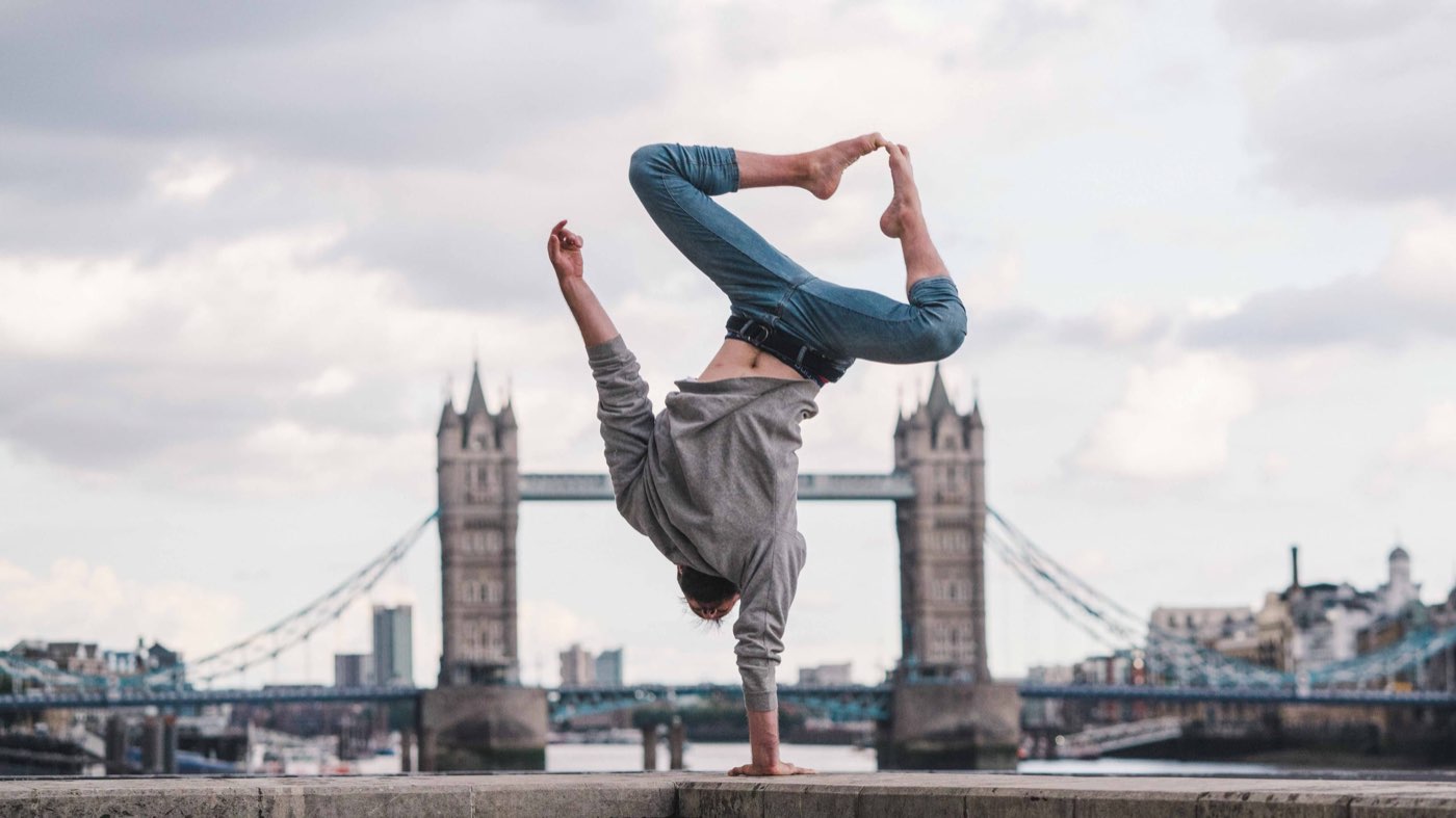 An acrobat mid-move with Tower Bridge behind