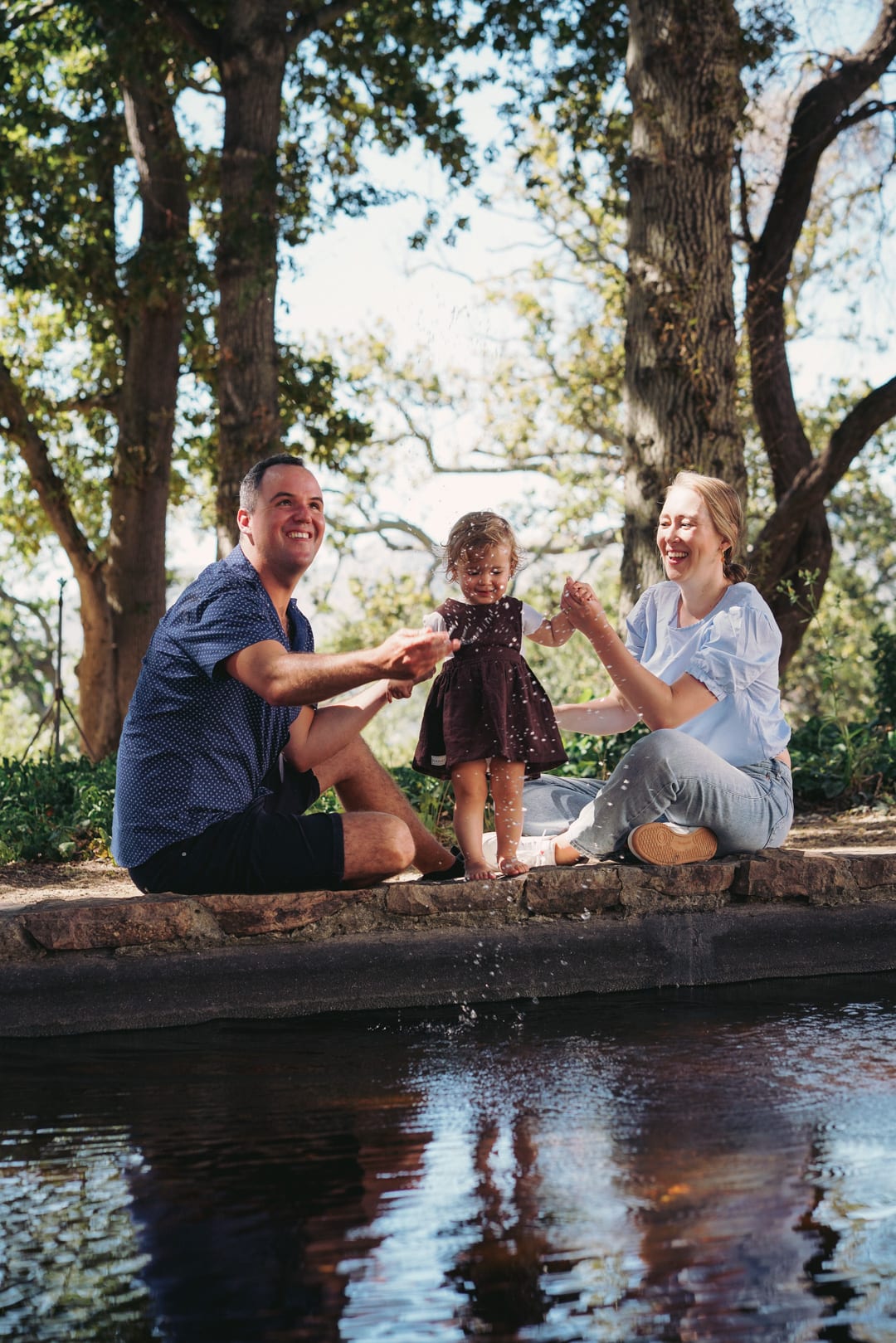 A family playing together beside a pond