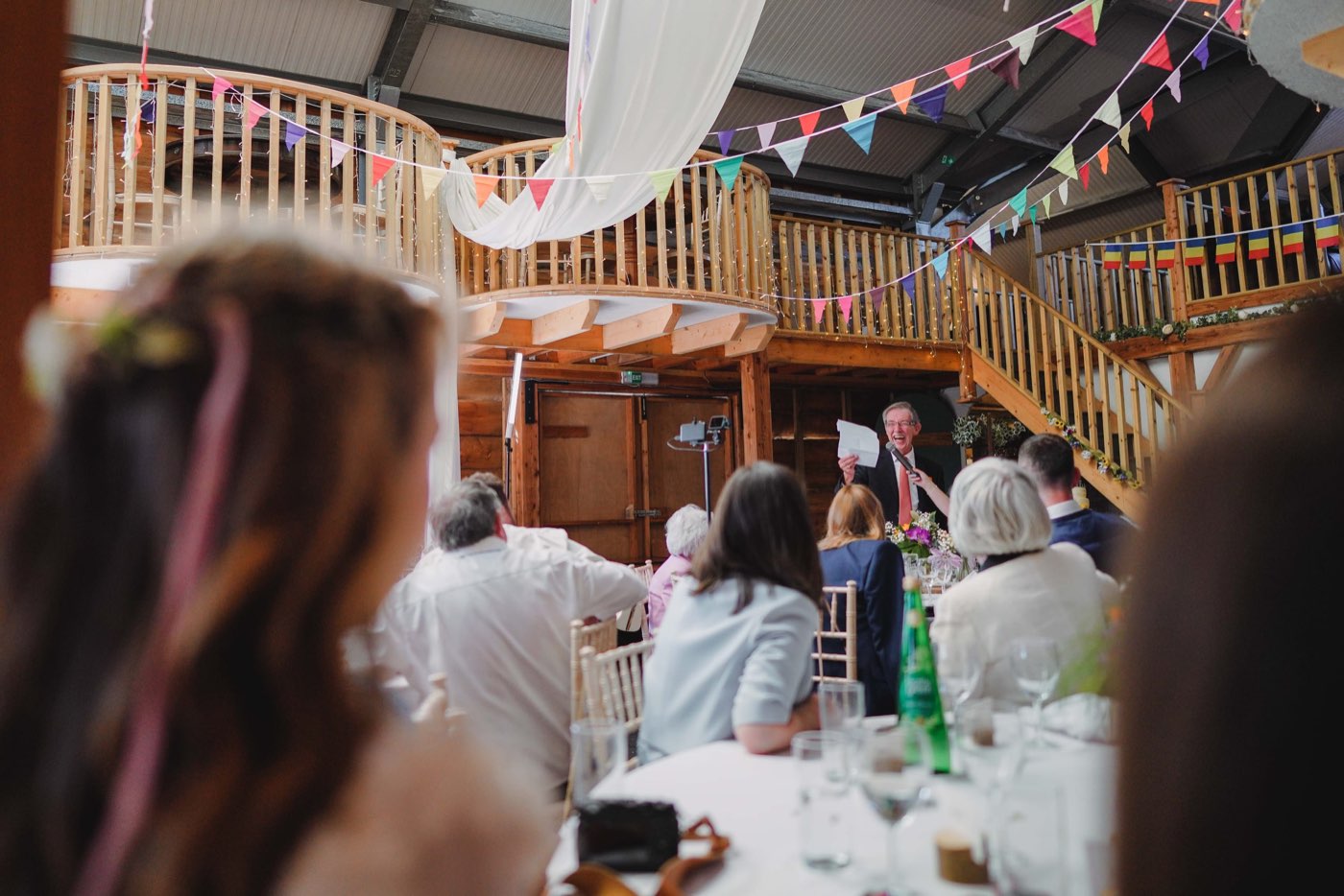 A wedding speech being given in a barn venue